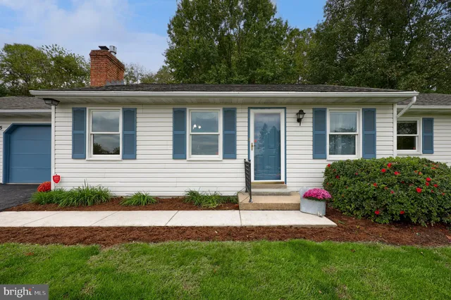 a front view of a house with a garden and plants