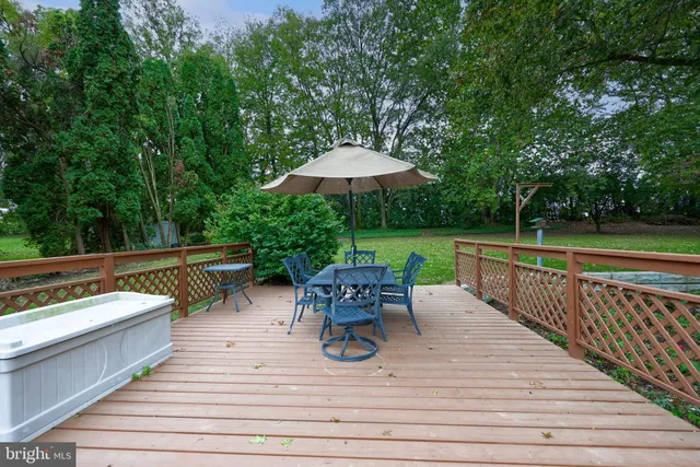 a view of a patio with dining table and chairs with wooden floor and fence
