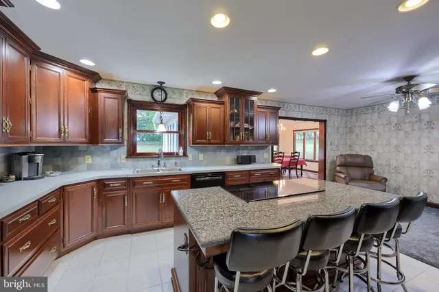 a kitchen with granite countertop a table chairs sink and cabinets