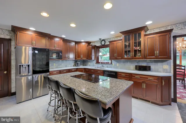 a kitchen with stainless steel appliances granite countertop a sink refrigerator and cabinets