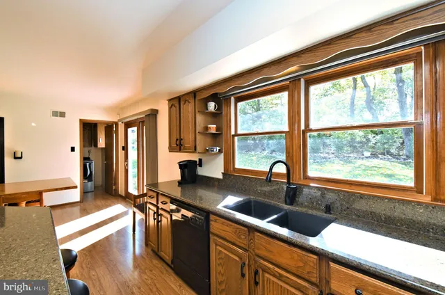 a kitchen with stainless steel appliances granite countertop a sink and a granite counter tops with a large window