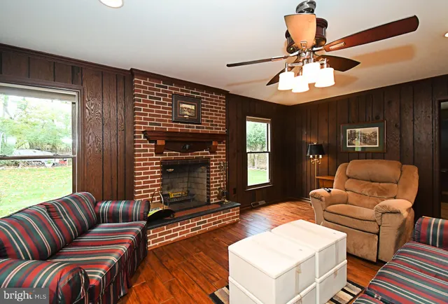 a living room with furniture ceiling fan and a window