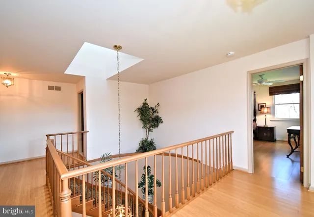 a view of a hallway with wooden floor and stairs