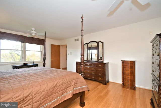 a bedroom with a bed and a dresser next to a window