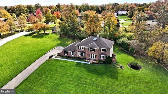 an aerial view of a house with yard and green space