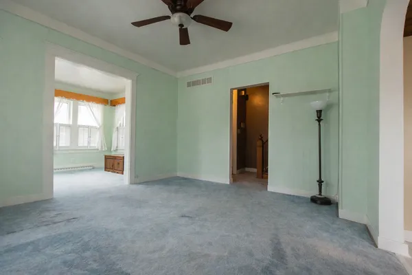 an empty room that has a window and a kitchen