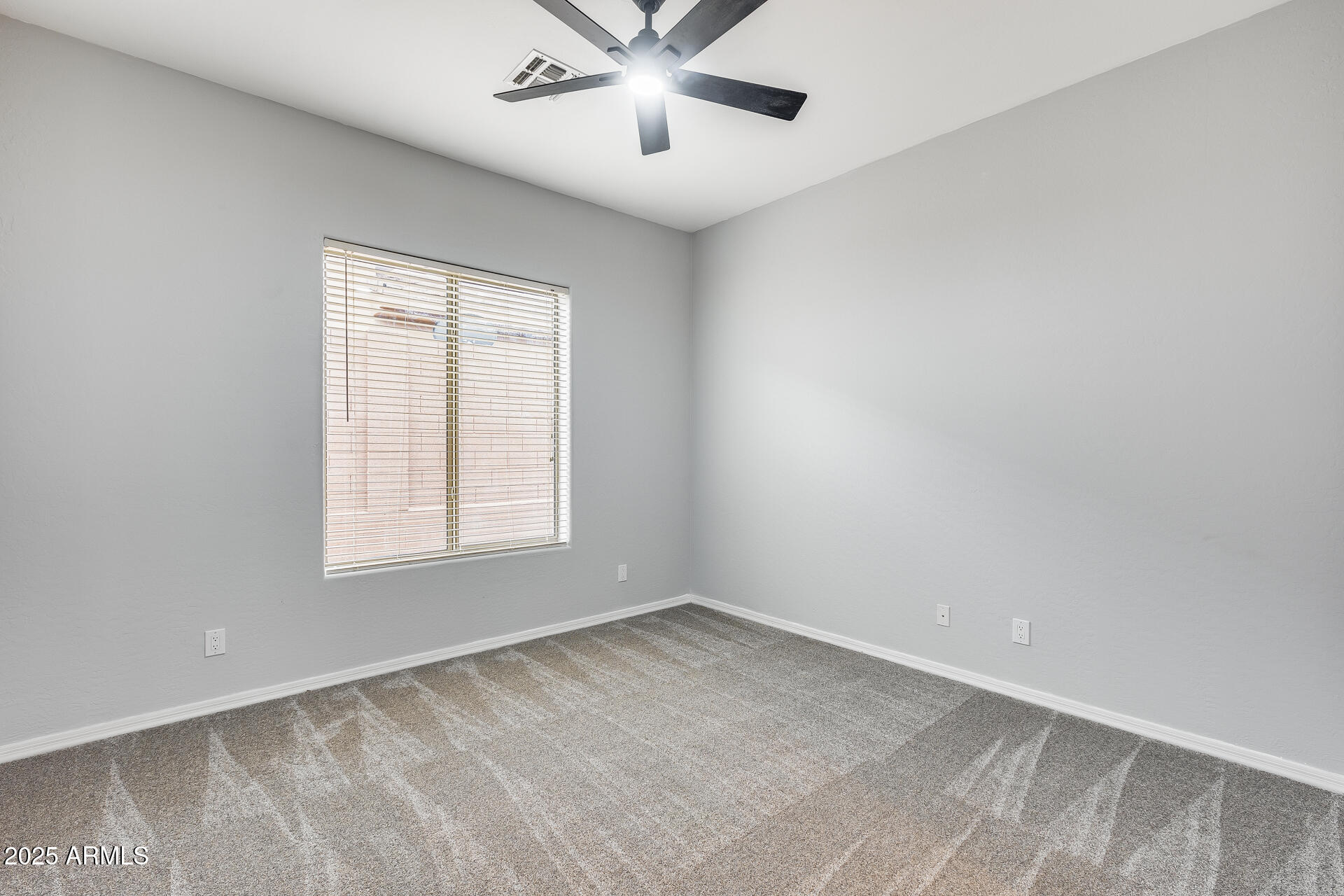 3138 West Ravina Lane Anthem, AZ 85086 - Photo 13 of 38 an empty room with a window and a fan