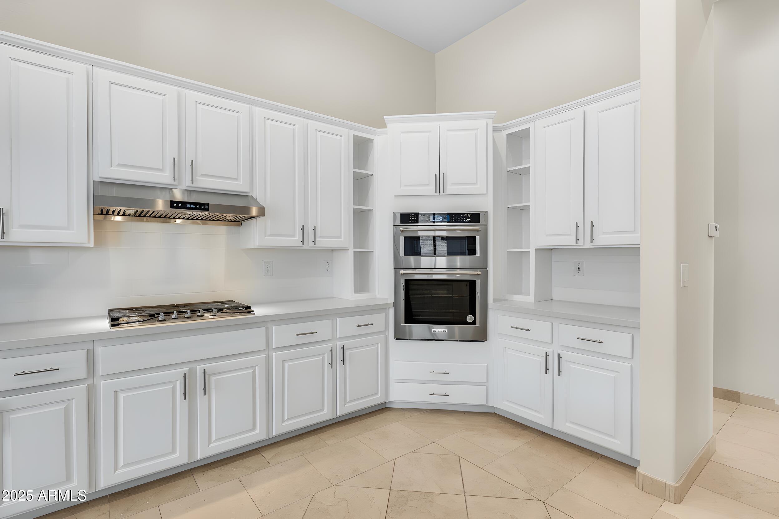 3138 West Ravina Lane Anthem, AZ 85086 - Photo 9 of 38 a kitchen with white cabinets and appliances