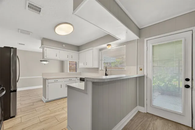 a kitchen with stainless steel appliances a sink cabinets and wooden floor