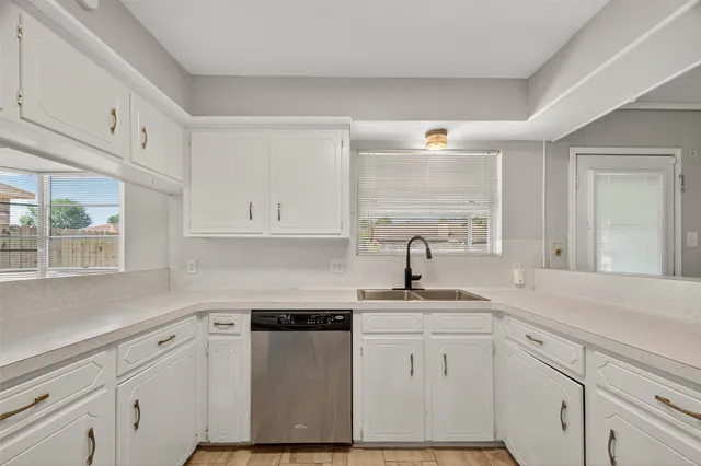 a kitchen with white cabinets white appliances and sink