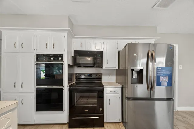 a kitchen with stainless steel appliances granite countertop a refrigerator and a stove top oven