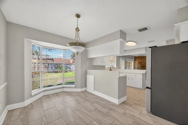 a view of kitchen with refrigerator and window