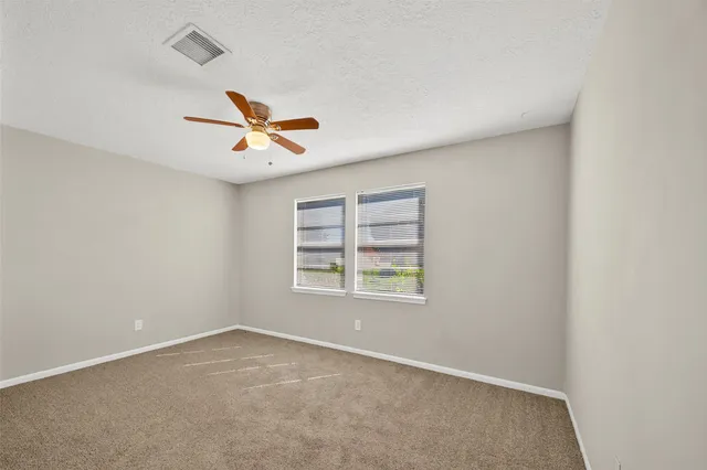 an empty room with a window and a ceiling fan