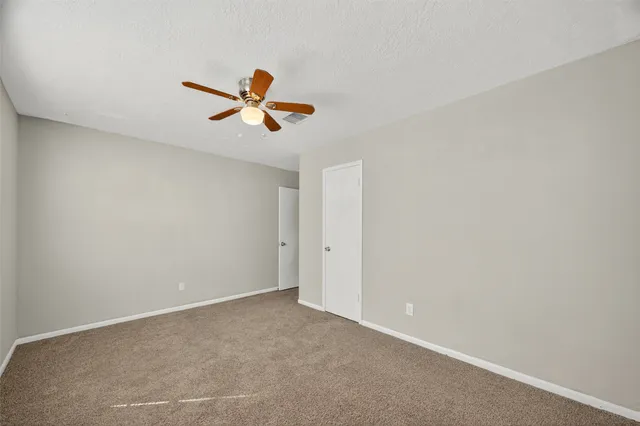 a view of a room with a ceiling fan and window