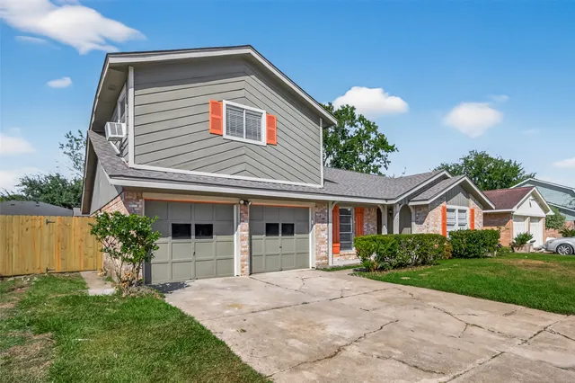 a front view of a house with a yard and potted plants
