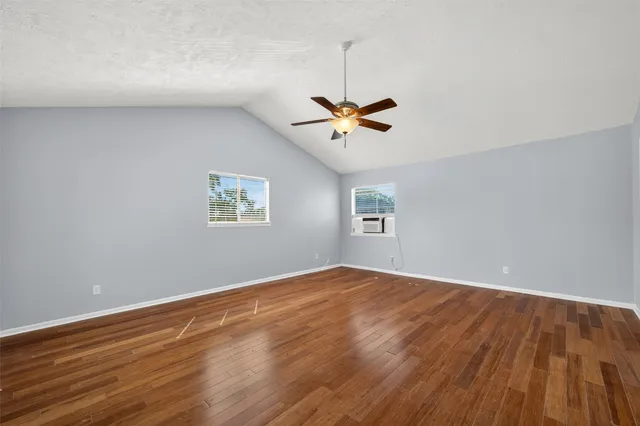a view of an empty room with a window and a ceiling fan