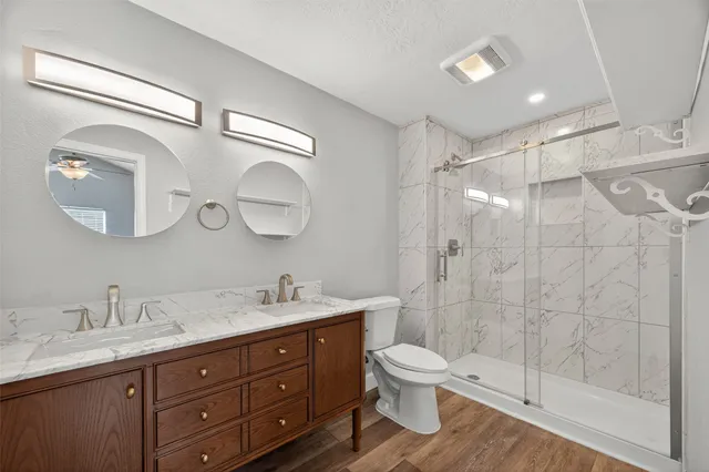 a bathroom with a double vanity sink mirror and toilet