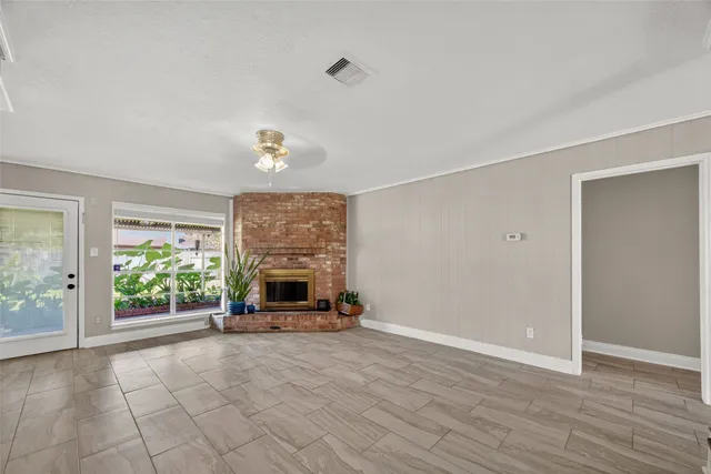 wooden floor fireplace and windows in an empty room