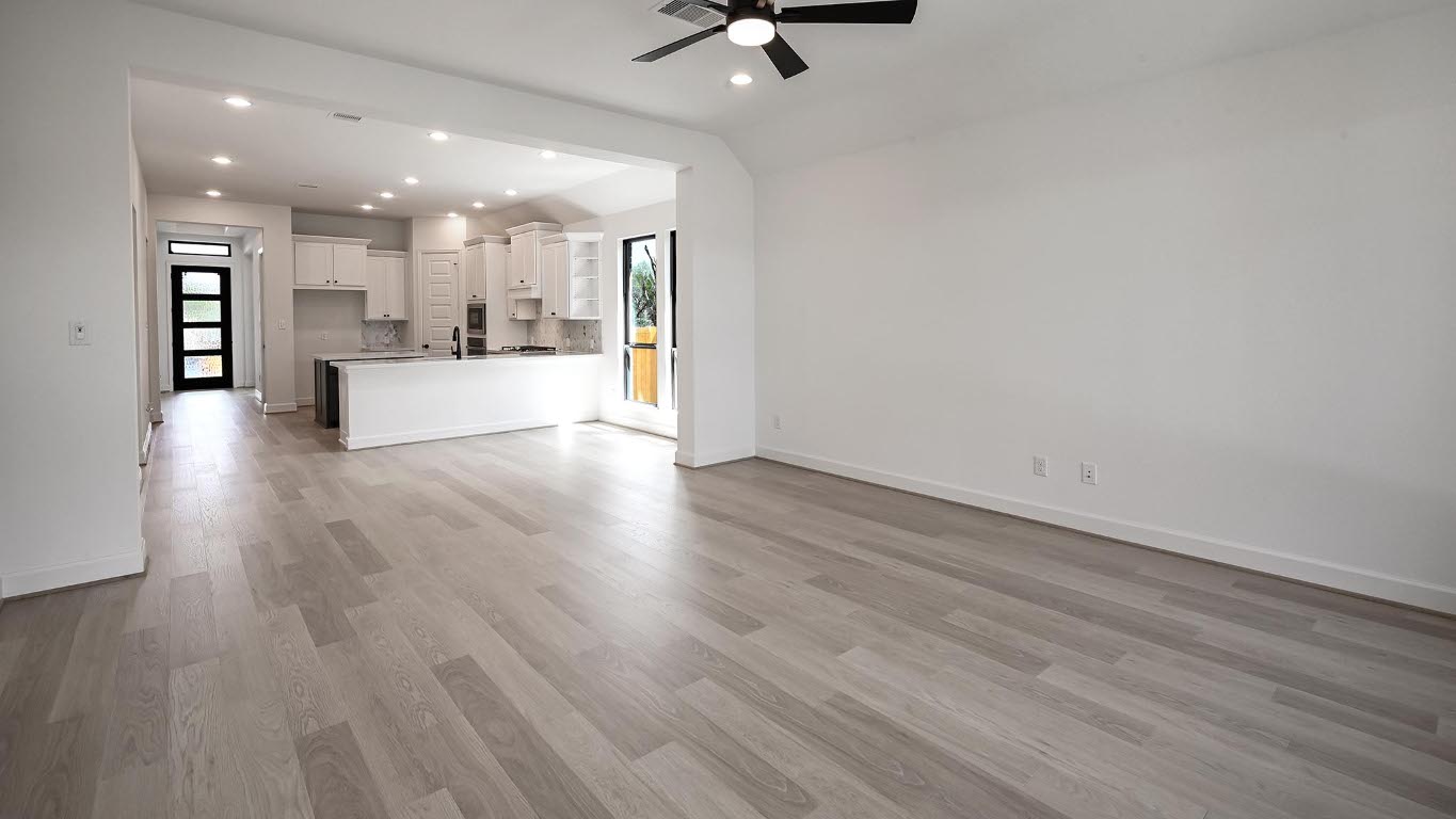 175 High Rock Pass Kyle, TX 78640 - Photo 24 of 39 Unfurnished living room featuring healthy amount of natural light, light wood finished floors, recessed lighting, ceiling fan, and lofted ceiling