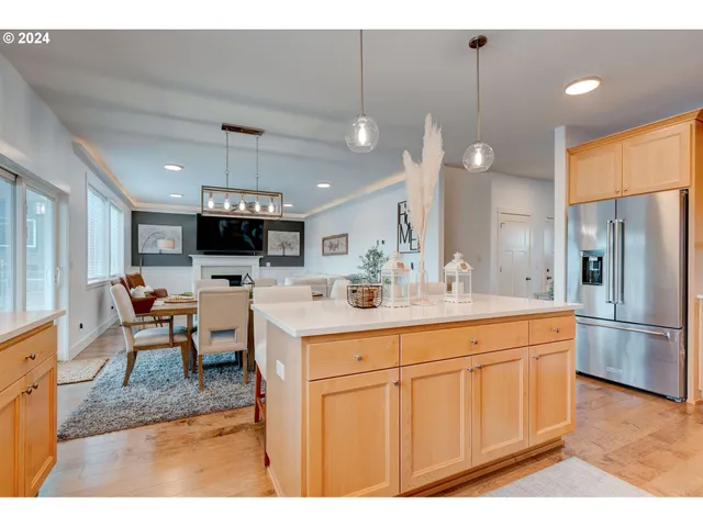 a kitchen with stainless steel appliances kitchen island granite countertop a sink refrigerator and cabinets