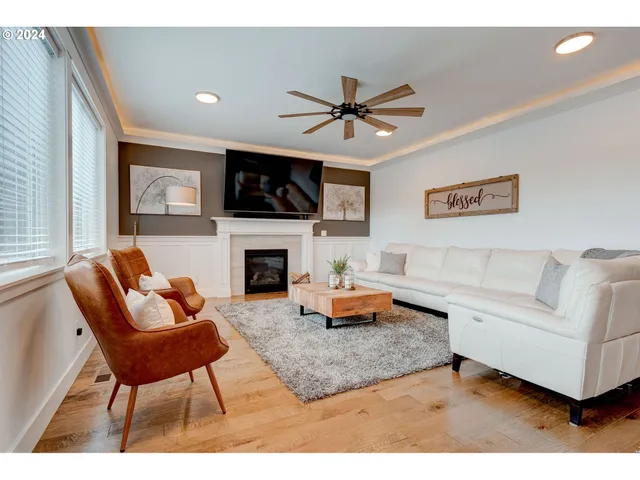 a living room with furniture a flat screen tv and a fireplace