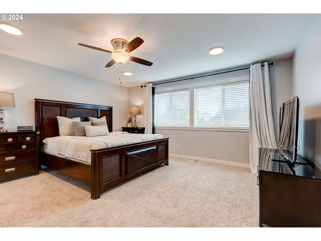 a bedroom with a large bed and a flat screen tv