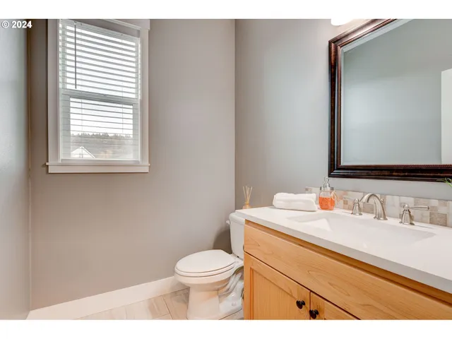 a bathroom with a toilet a sink a vanity and mirror