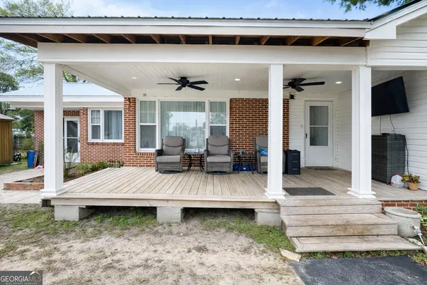 a view of a patio with table and chairs potted plants with wooden floor
