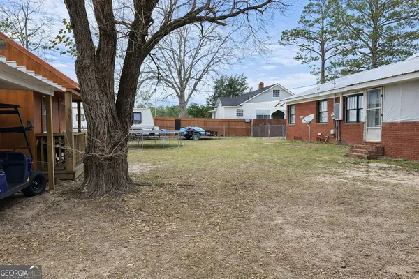 a view of a yard with a house and a large tree