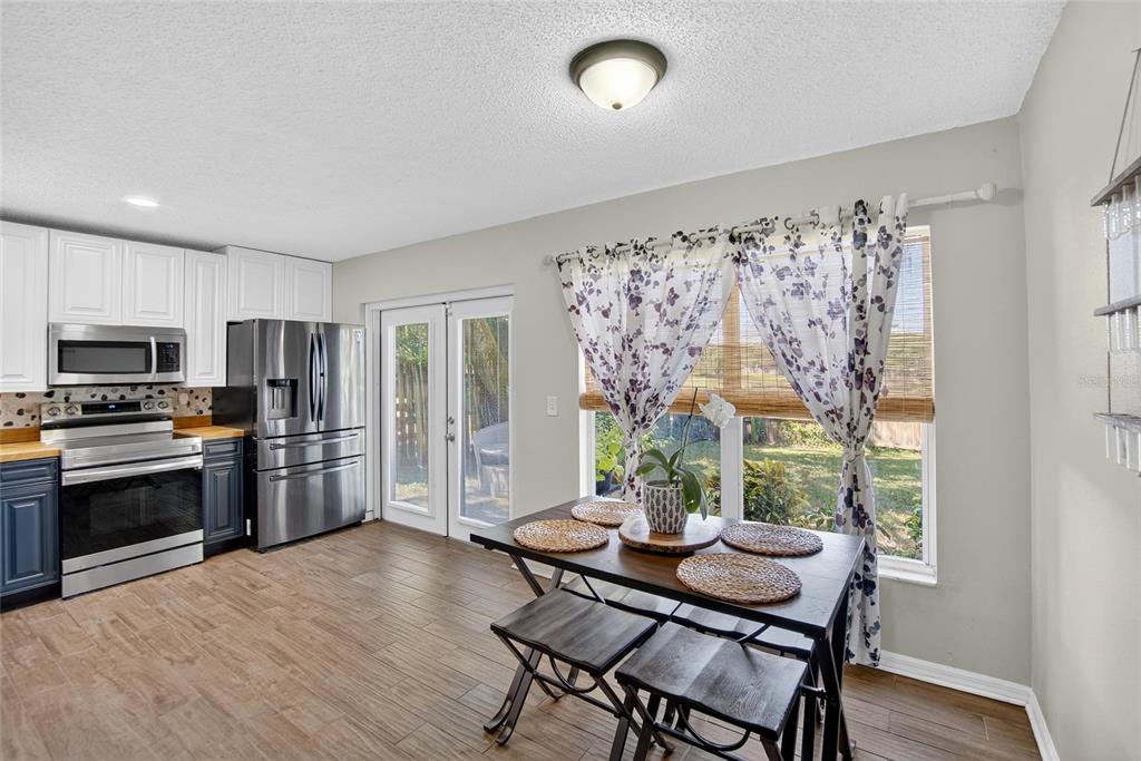 630 Cape Cod Circle Valrico, FL 33594 - Photo 13 of 48 a kitchen with stainless steel appliances granite countertop a stove top oven a refrigerator and a dining table with wooden floor