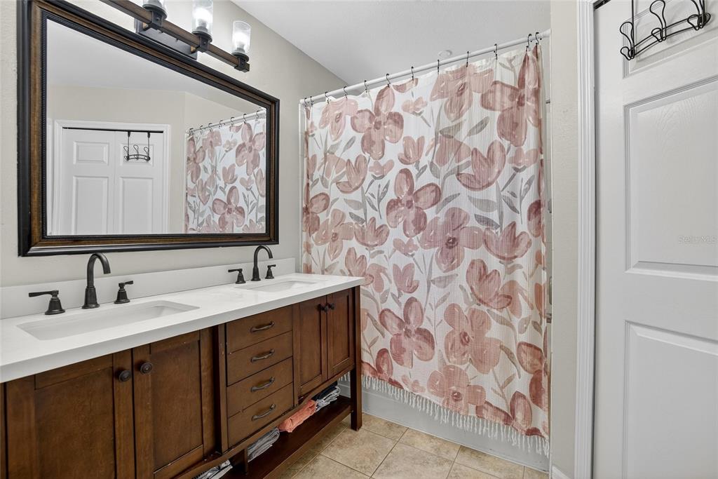 630 Cape Cod Circle Valrico, FL 33594 - Photo 21 of 48 a bathroom with a double vanity sink a mirror a and a shower curtain
