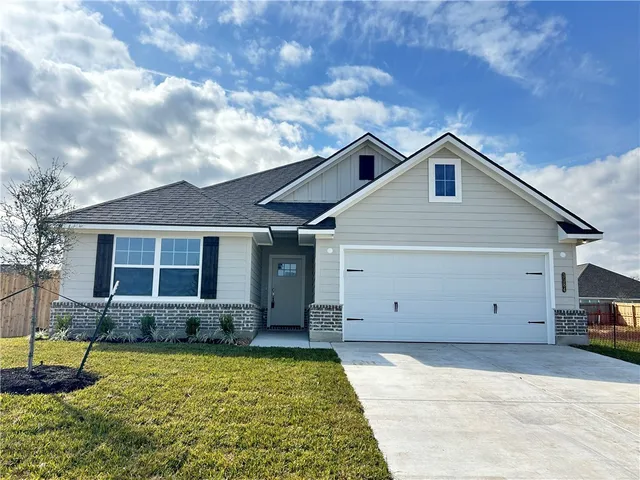 a view of a house with backyard and a tree