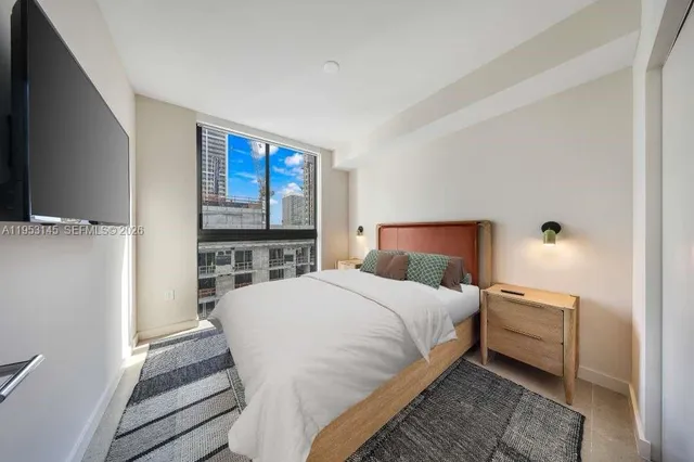 a bedroom with a bed and a flat screen tv