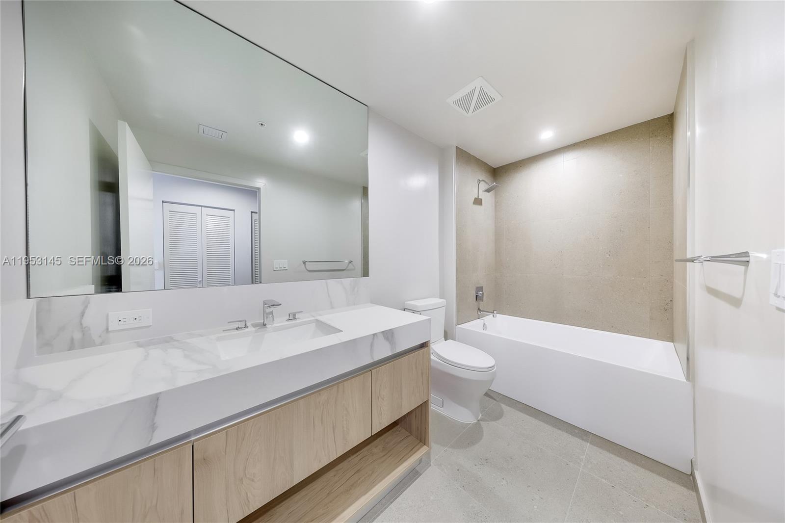 11 Northeast 6th Street, Unit 3209 Miami, FL 33132 - Photo 16 of 30 a bathroom with a double vanity sink toilet mirror and bathtub