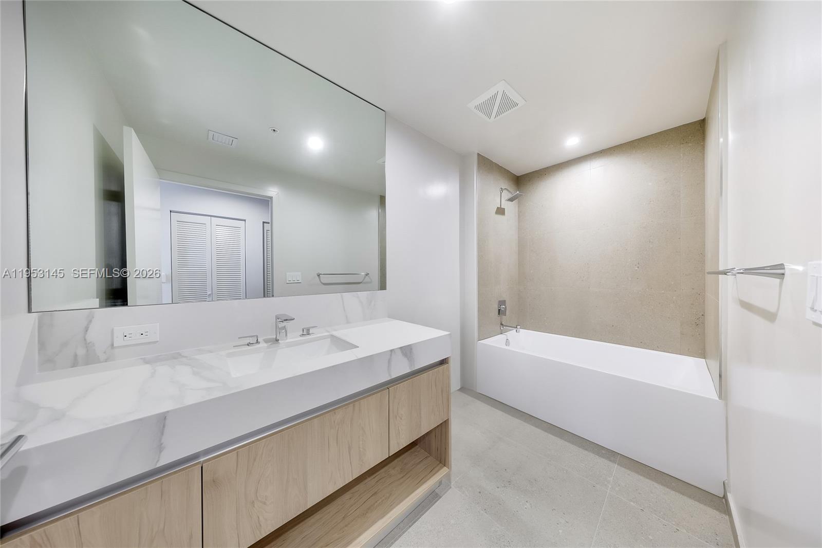 11 Northeast 6th Street, Unit 3209 Miami, FL 33132 - Photo 17 of 30 a bathroom with a tub a sink and mirror