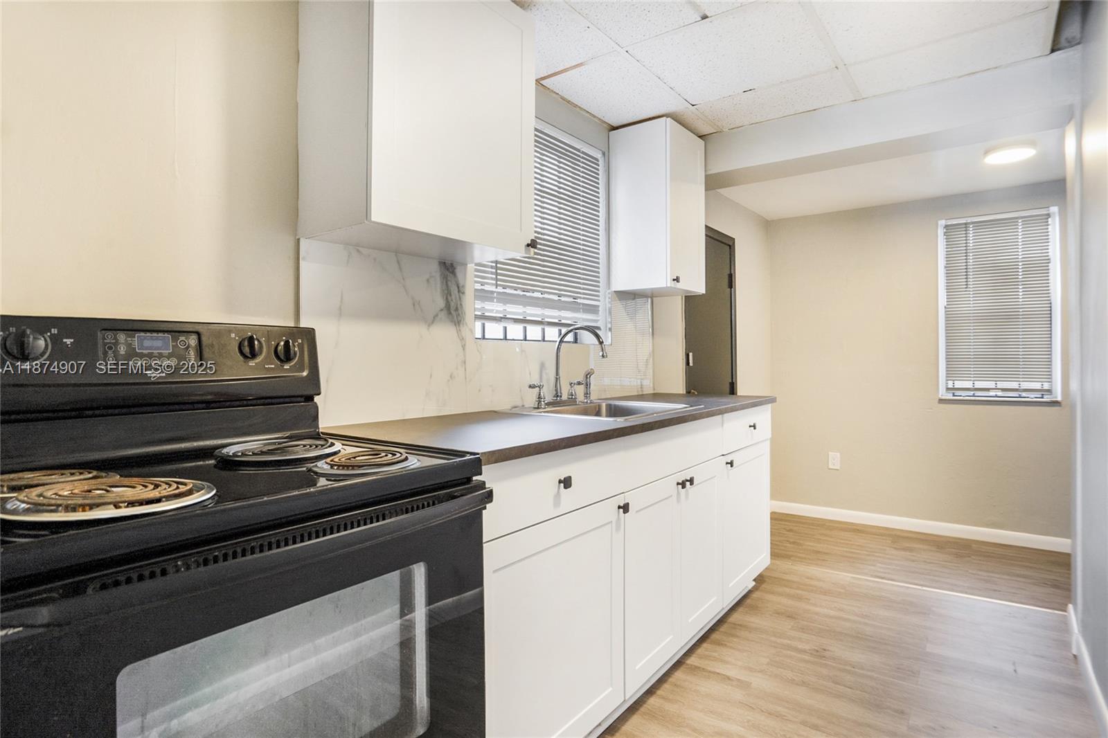 6535 Northwest 6th Avenue Miami, FL 33150 - Photo 3 of 14 a kitchen with granite countertop a stove and a sink