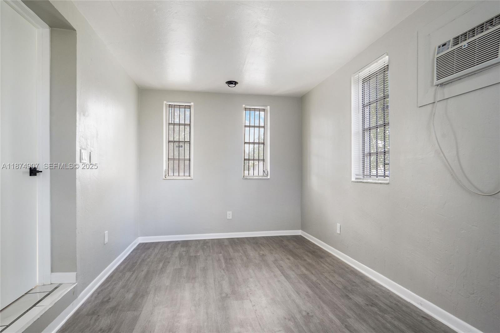 6535 Northwest 6th Avenue Miami, FL 33150 - Photo 9 of 14 an empty room with wooden floor and windows