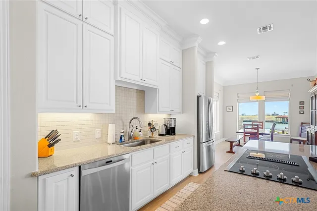 a kitchen with kitchen island a large counter top space appliances and cabinets