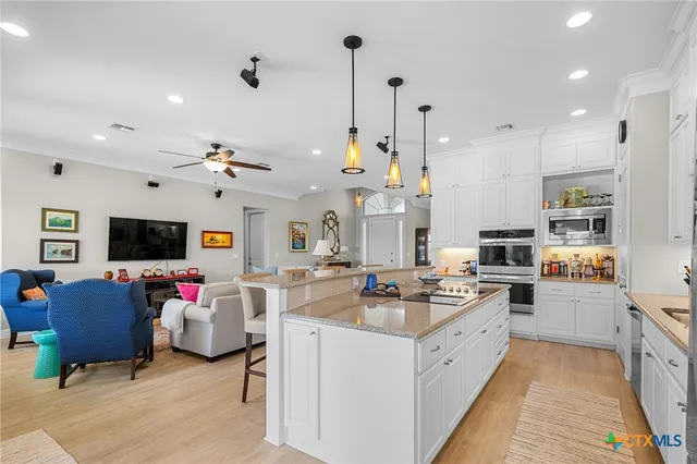 a living room with furniture kitchen view and a flat screen tv