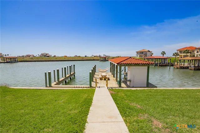 a view of a swimming pool with lawn chairs under an umbrella