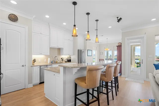 a open kitchen with stainless steel appliances granite countertop a sink stove and living room view