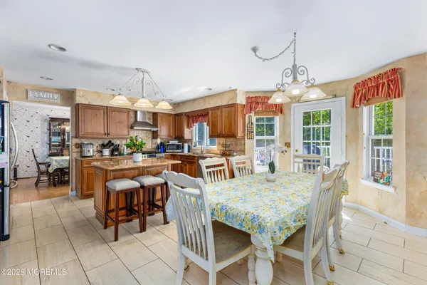 a dining room with granite countertop a table chairs and a chandelier