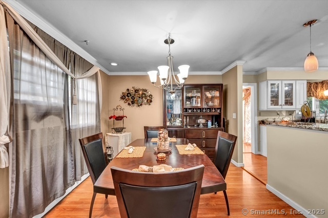 77 Oxbow Lane West Haven, CT 06516 - Photo 11 of 27 a dining room with furniture a chandelier and wooden floor