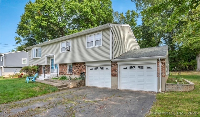 77 Oxbow Lane West Haven, CT 06516 - Photo 3 of 27 a front view of a house with a yard and garage