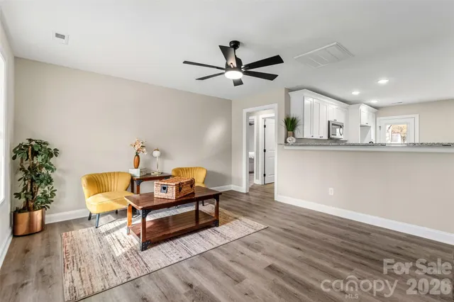 a living room with furniture and a wooden floor