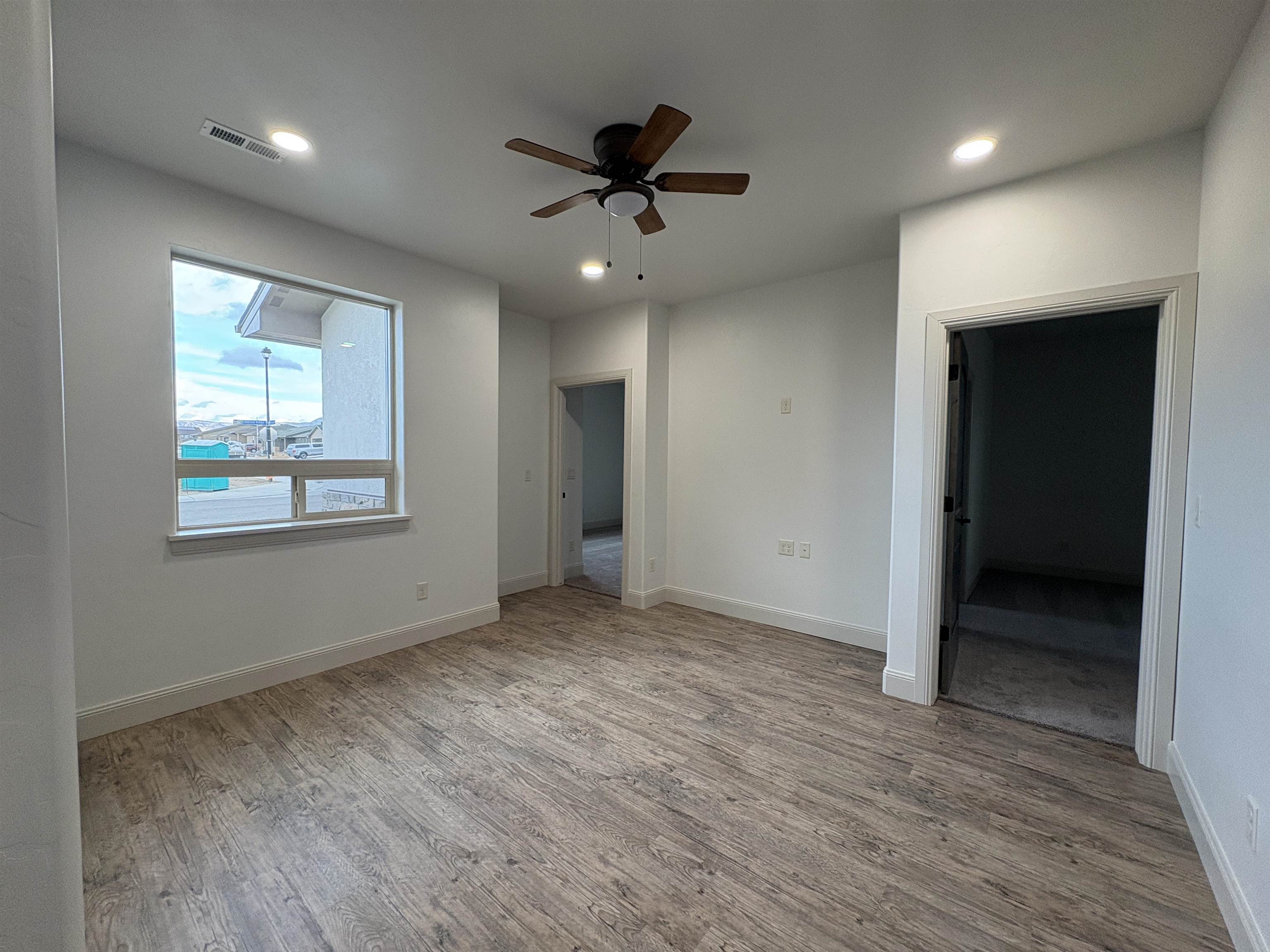 2641 Emerald Ridge Lane Grand Junction, CO 81506 - Photo 7 of 42 an empty room with wooden floor and a ceiling fan