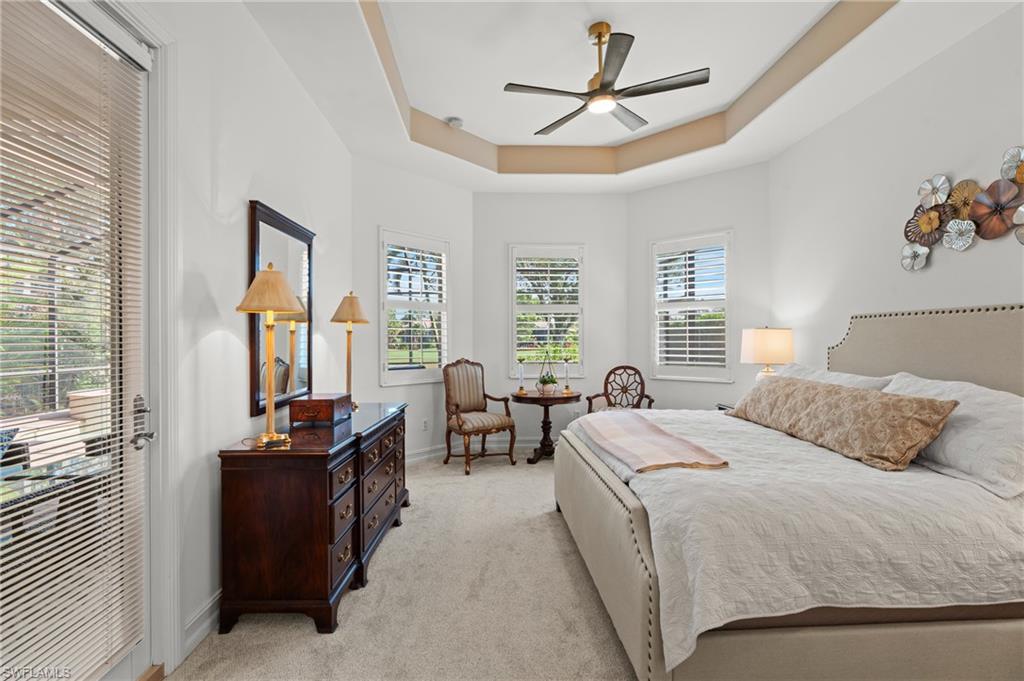 7806 Ashton Road Naples, FL 34113 - Photo 13 of 27 Bedroom featuring multiple windows, light colored carpet, baseboards, and a raised ceiling
