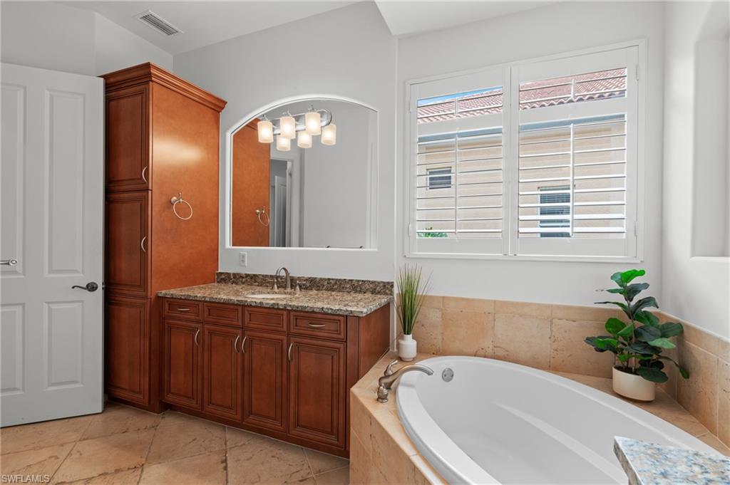 7806 Ashton Road Naples, FL 34113 - Photo 14 of 27 Full bath featuring a bath, visible vents, a healthy amount of sunlight, and vanity