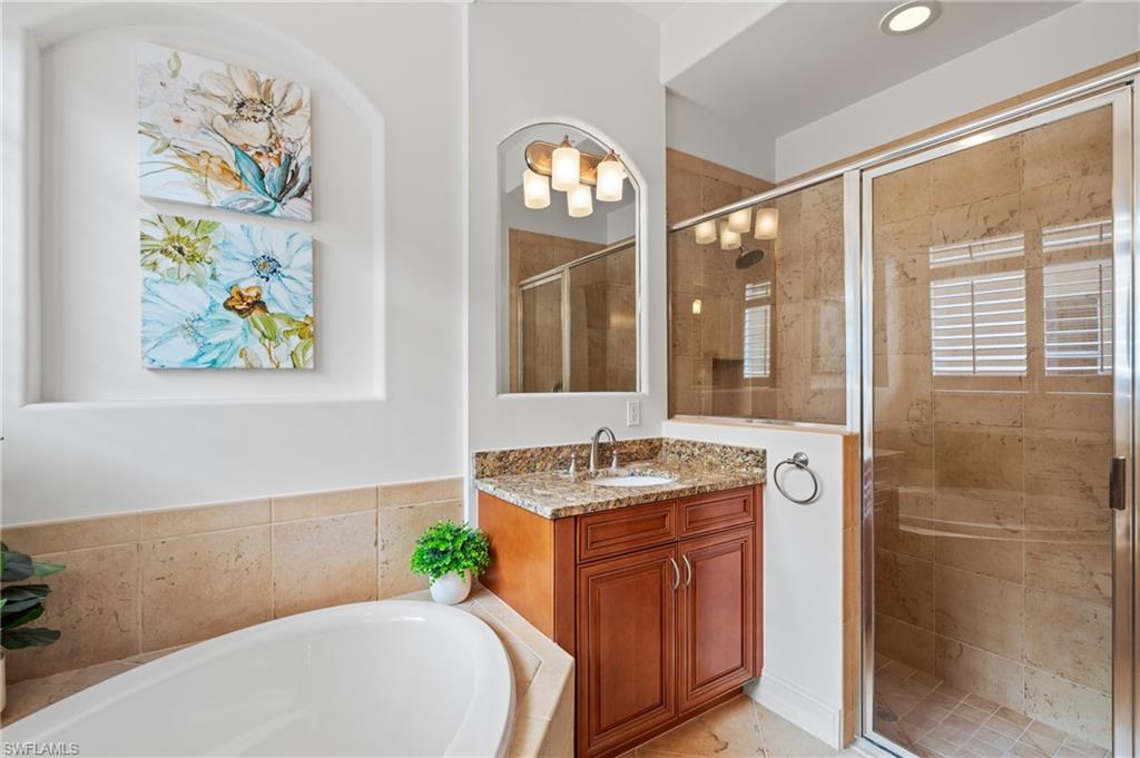 7806 Ashton Road Naples, FL 34113 - Photo 15 of 27 Bathroom featuring a shower stall, a bath, and vanity