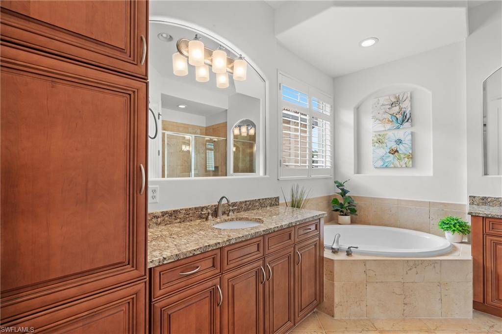 7806 Ashton Road Naples, FL 34113 - Photo 16 of 27 Bathroom with tile patterned flooring, vanity, a garden tub, and a shower stall